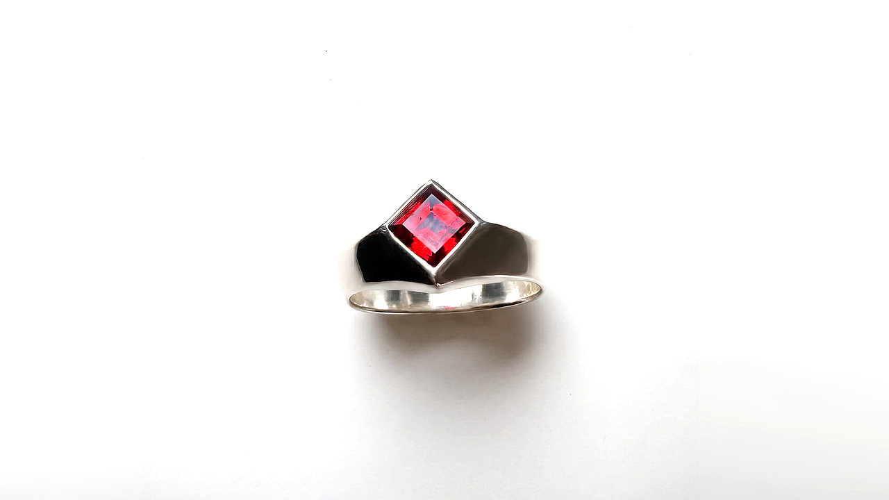 The ring from the front, the garnet lit brightly by the light.