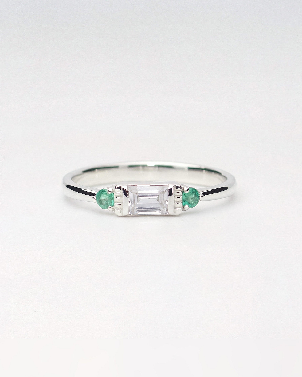 Trilogie Ring mit farblosem Saphir und Smaragd