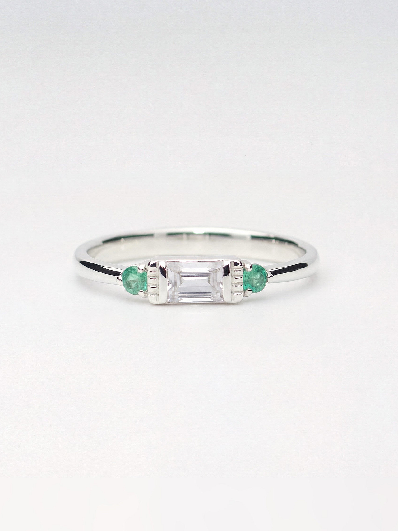 Trilogie Ring mit farblosem Saphir und Smaragd